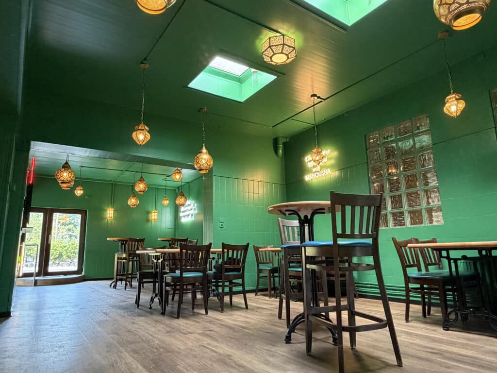 Blick in den Gastraum des Fatima-Bistro in Malente. Dunkelgrün gestrichene Wände, orientalische Lampen an den Decken und Wänden und ein Holzfußboden geben dem Bistro einen orientalischen Flair.